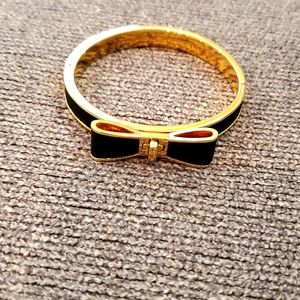 Black and gold Kate Spade bangle bracelet with clasp opening